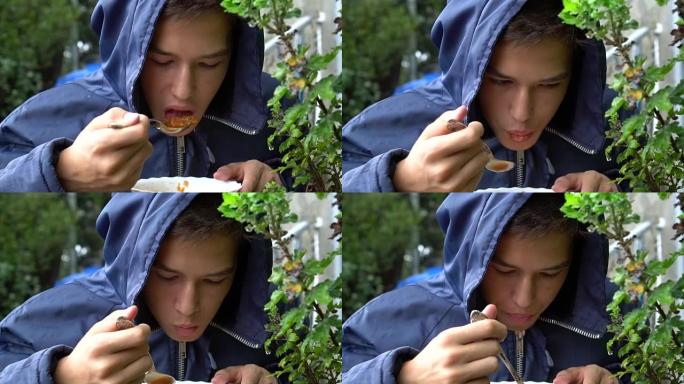 一个少年在雨中在外面吃饭