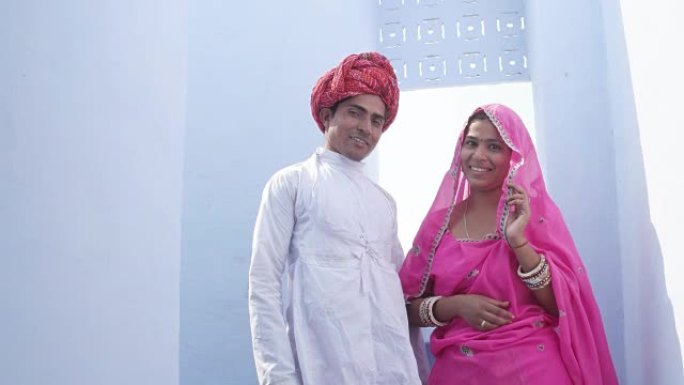 在印度拉贾斯坦邦，一对穿着传统服装的炫酷印度夫妇摆出俯视镜头的姿势