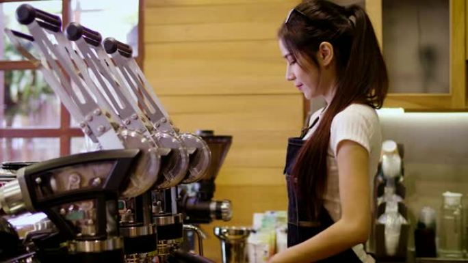 年轻微笑的亚洲女性咖啡师或女性咖啡老板使用咖啡机，在咖啡店咖啡馆寻找相机