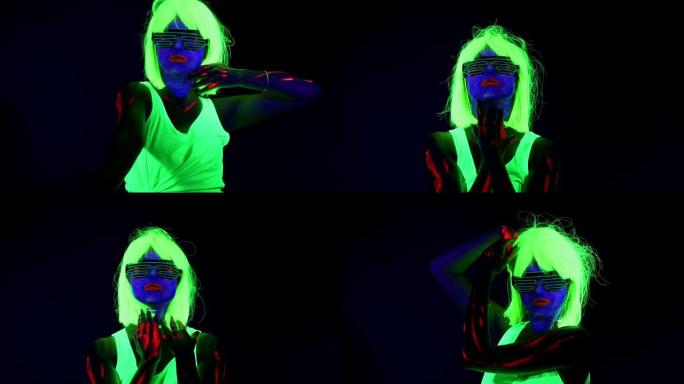女人用紫外线的脸漆，假发，发光的衣服在镜头前跳舞。高加索女人。。