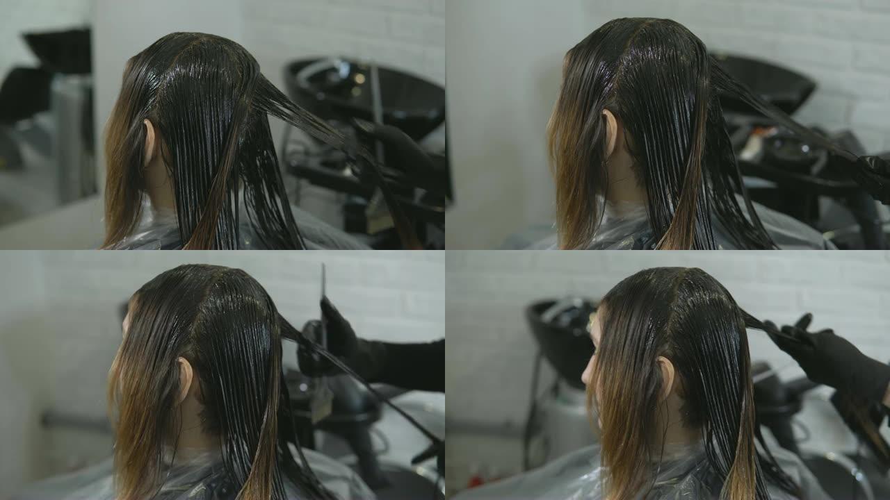 造型师在美容院画一个年轻女人的头发。