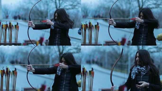 练习射箭的旅游女子。女人专注于用箭击中目标。女子弓箭手用4k弓射击
