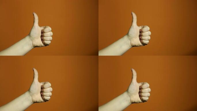 双手的概念的手势显示拇指向上，因为获胜者的庆祝和祝贺孤立在橙色背景上