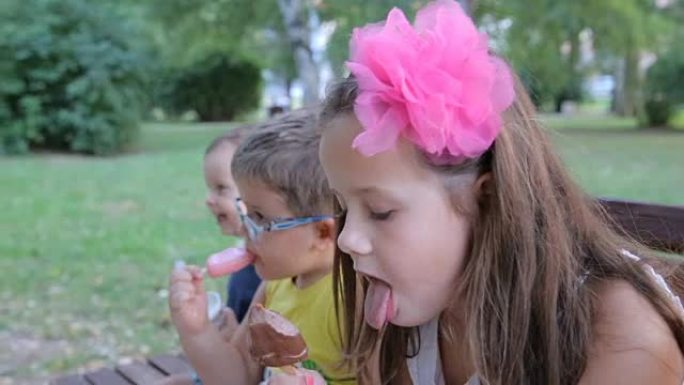 坐在长凳上吃冰淇淋的孩子们