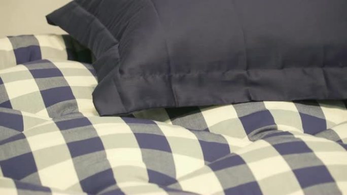 床上有蓝色和白色床单的蓝色枕头