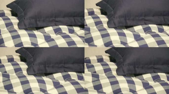 床上有蓝色和白色床单的蓝色枕头