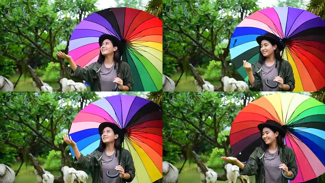 玩雨滴的女人一边用彩虹伞一边微笑