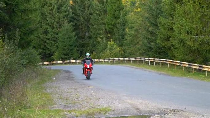 一个骑摩托车的人。年轻帅哥在山路上骑摩托车。