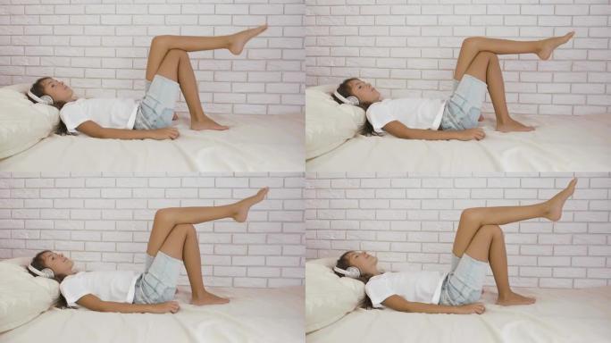 一个躺在床上的孩子正在听音乐。