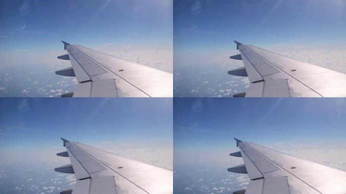 当太阳照耀时，飞机机翼从飞机窗户飞出，蓝天云彩