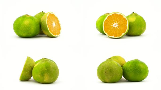两个完整的半切绿色橘子果实，带有水滴。在转盘上旋转。孤立在白色背景上。特写。宏观。