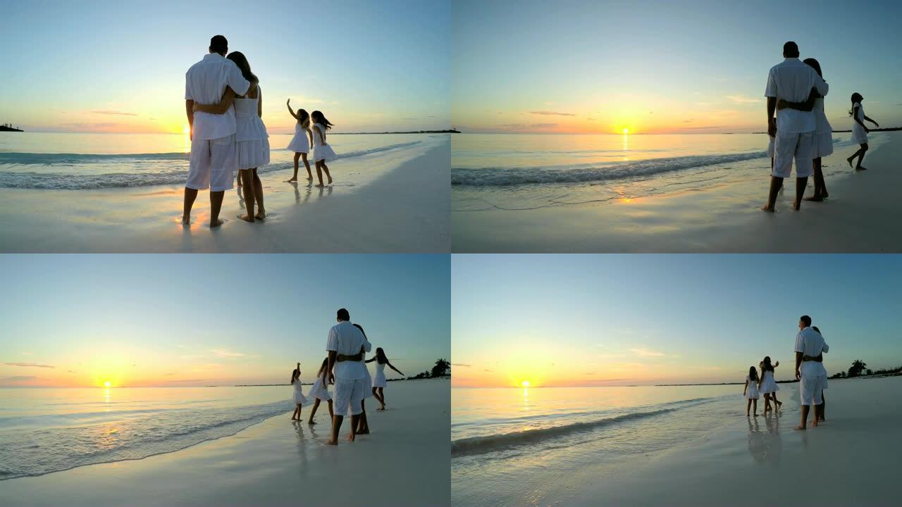 白种人家庭赤脚穿着白衣服在海滩上