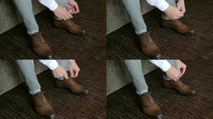 男子在棕色皮鞋上系鞋带，特写镜头。