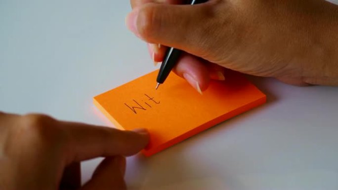 在橙色的便签纸或记事本上手写 “有爱” 一词