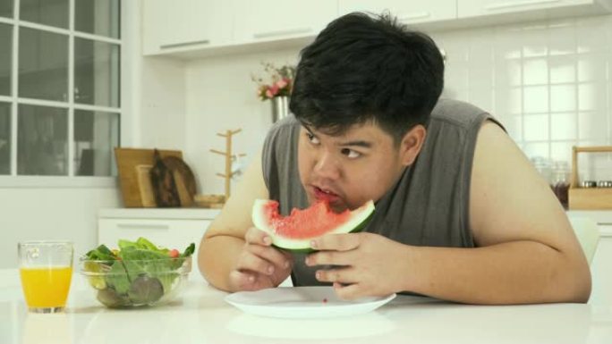 侧视图: 泰国超重男子吃西瓜等健康食品感到饥饿