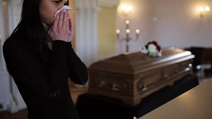 在教堂的葬礼上用擦拭和棺材的女人