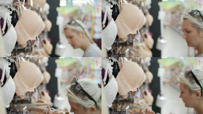 模糊的年轻金发女子在商店里选择胸罩的特写镜头