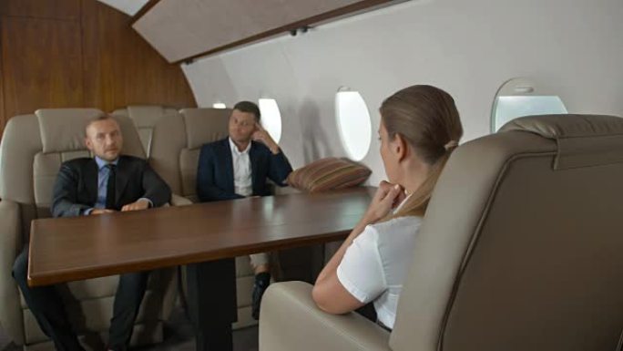 两名自信的男性企业家和成功的女商人乘坐头等舱飞机