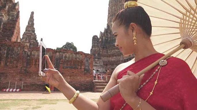 泰国年轻女子穿着泰国民族礼服套装在大城府老庙散步
