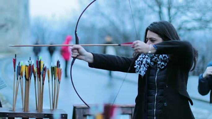 女子弓箭手用4k弓射击。练习射箭的旅游女子。女人专注于用箭击中目标。