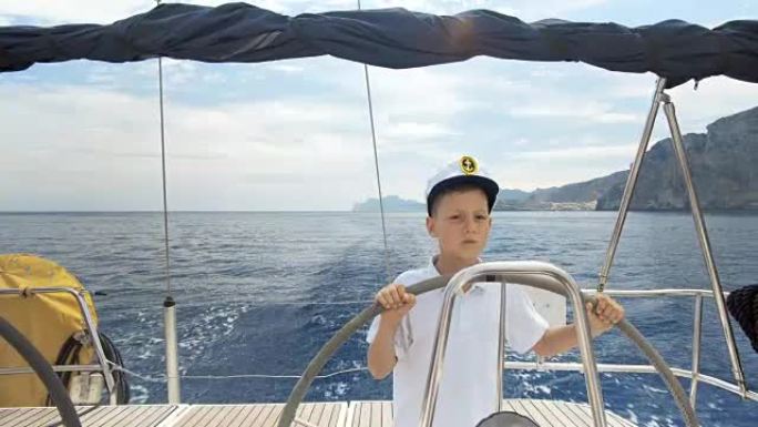 Litle儿童船长在比赛中控制帆船的驾驶