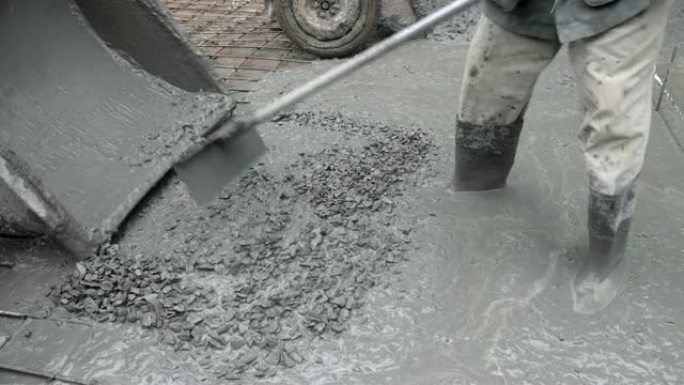 在农村道路上浇筑水泥的建筑工人的特写