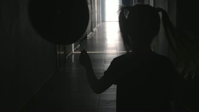 气球沿着走廊奔跑的小女孩的轮廓
