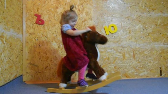 女孩，骑马玩具上的孩子，骑马，在托儿所里摇摆