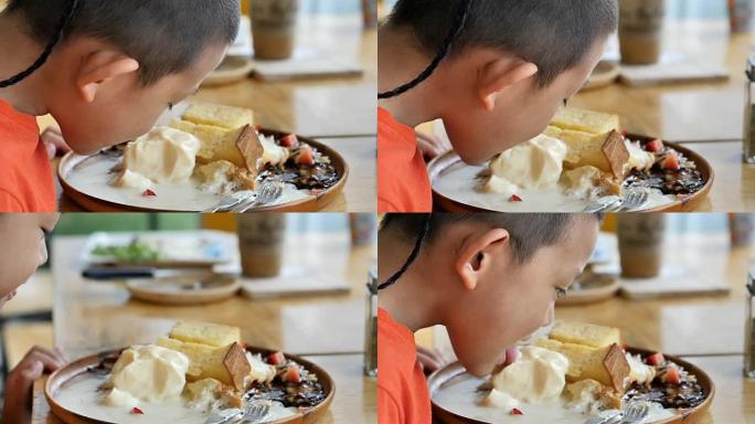 可爱的亚洲儿童在餐厅快乐地吃冰淇淋