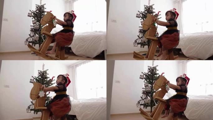 带长凳玩具的亚洲可爱女孩正在家里玩圣诞树装饰