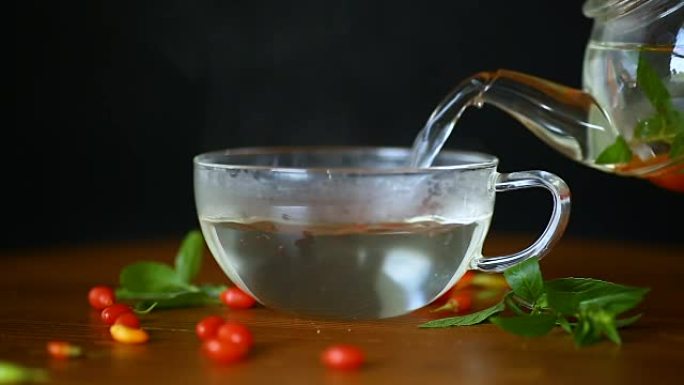 在玻璃茶壶中从成熟的红色枸杞浆果中获得热茶