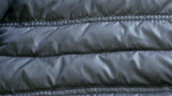 暖冬羽绒服的合成表面慢倾斜4K 2160p 30fps超高清镜头-管壁填充夹克的特写3840X216