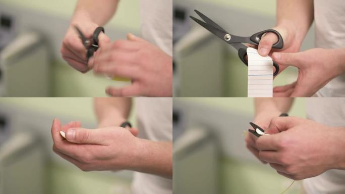 男性双手的特写镜头，手持一块折叠的切割的黄色kinesiotape和剪刀。他切角以修剪它，沿着中心线