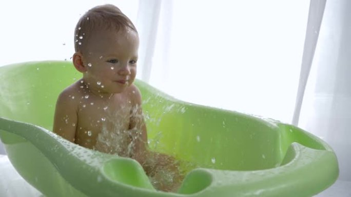 婴儿洗澡，微笑的小男孩洗澡时被玩水