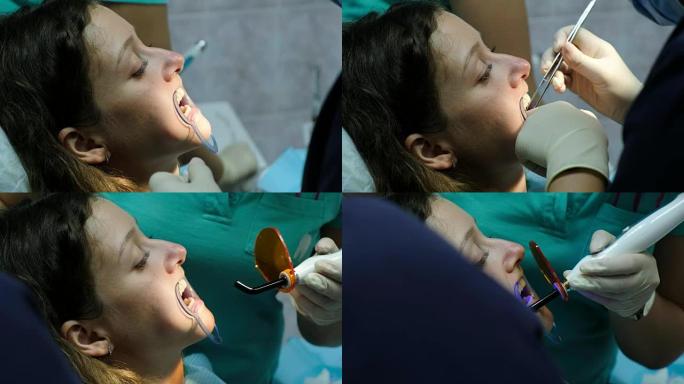 口腔科医生将棉签放在女人的嘴里，助手用牙齿上的聚合紫外线灯照射到病人的牙齿上。去看牙医