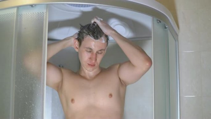 一个英俊的男人在洗澡的时候洗他的头