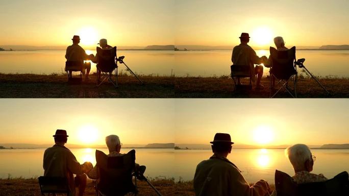 高级夫妇在湖边欣赏日落美景，慢动作