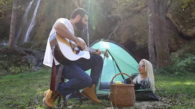 一个男人在露营时弹吉他