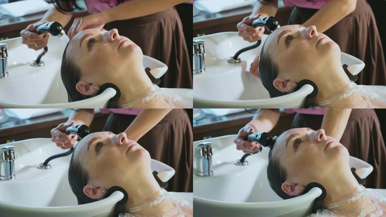 美发师在美容工作室洗女人的头发。