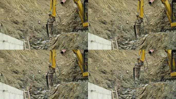 挖掘机上的大型气动锤在建筑工地的采石场中砸碎岩石。