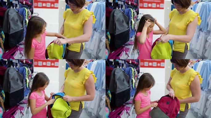 商店货架附近的高加索母女在小百货市场选择书包背包