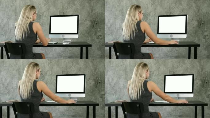 女商人在创意办公室使用台式电脑。白色显示