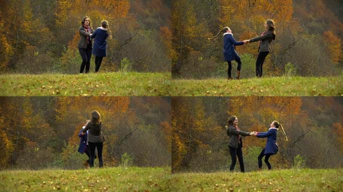 一位年轻的母亲和她的小女儿在秋天的森林里玩耍。妈妈和女儿手牵着手愉快地旋转。他们很高兴。