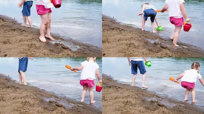 小女孩和男孩用水桶从河里打水，动作缓慢。孩子们在沙滩上的沙滩上玩耍