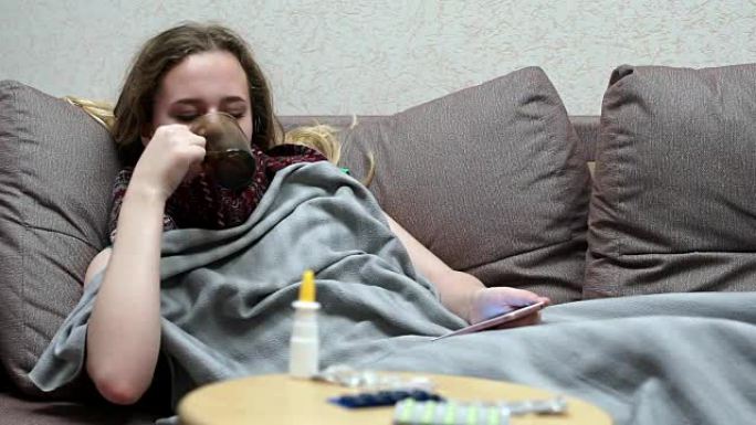 少女喝药茶温热。躺在沙发上，带着智能手机