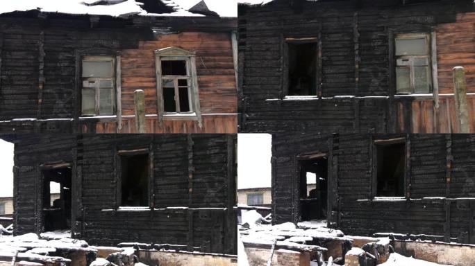火灾后的木屋。烧毁的旧木制建筑。旧原木被火烧毁。大火烧焦的原木末端后，一座旧木屋的墙壁碎片