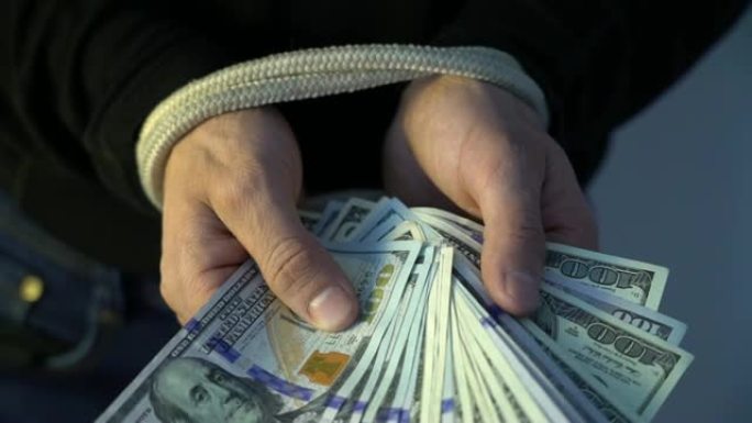 男性用绳子绑着一堆钱美元钞票，金融监管概念