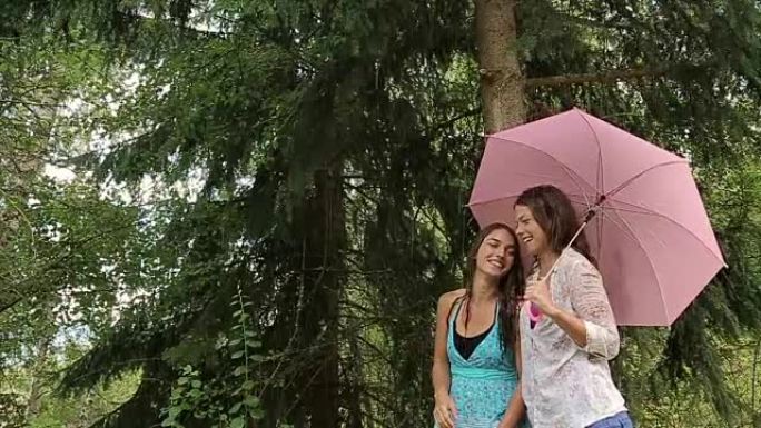 两名女生用粉红色雨伞微笑，雨林景象