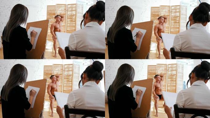 女孩在画布上画一个肌肉发达的光着膀子的男人