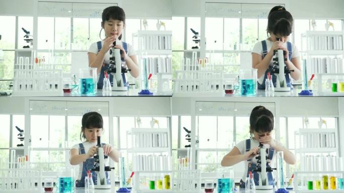 dolly拍摄的前视图: 好奇的亚洲女孩根据自己的意愿调整光学显微镜